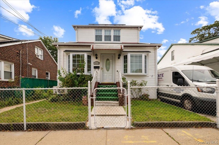 Traditional home with a gate and a fenced front yard