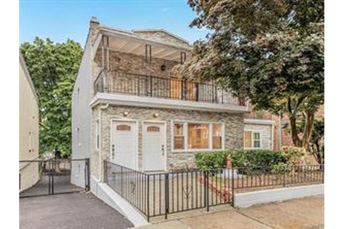 View of front of home featuring a fenced front yard and a balcony