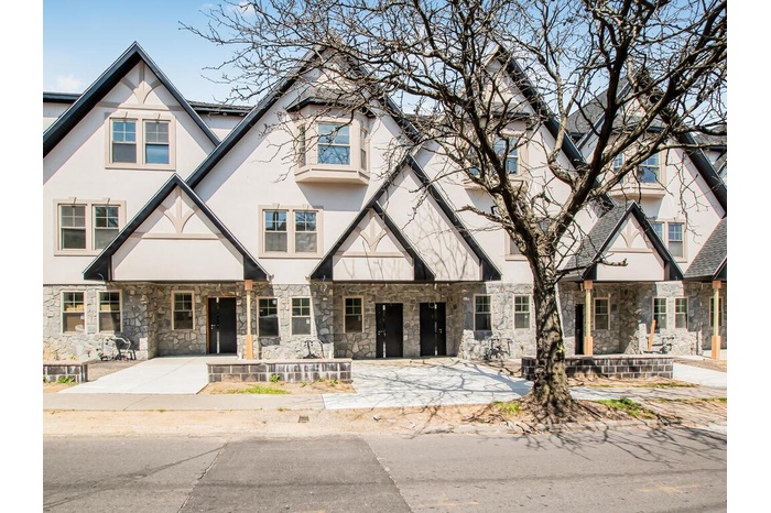 View of front of house featuring stucco siding and stone siding