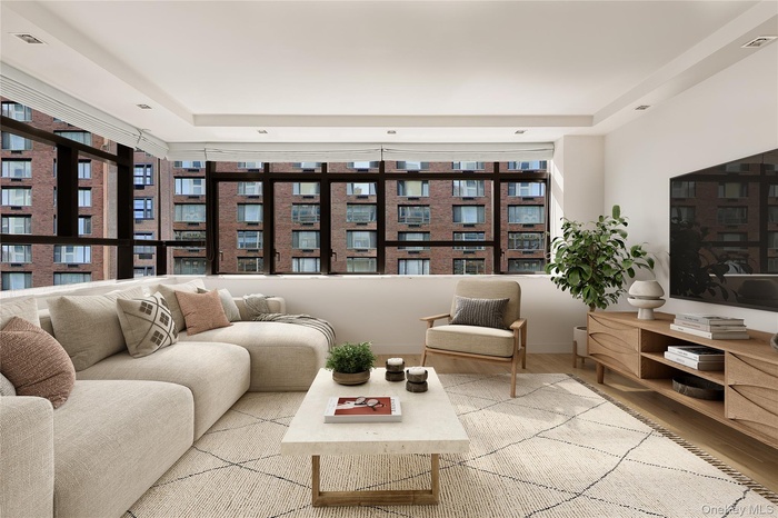 Living area with wood finished floors and a raised ceiling
