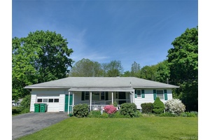 This pleasant, three bedroom ranch sits unassuming on a green and level 1.