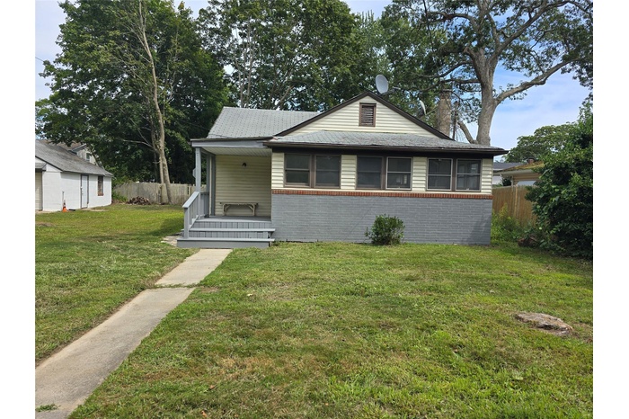 Bungalow-style house with a porch, brick siding, and a chimney