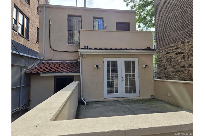 View of exterior entry with stucco siding and french doors