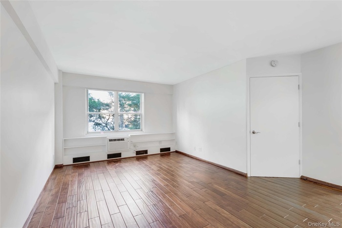Additional living space featuring wood finished floors and baseboards