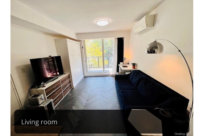 Living room featuring an AC wall unit