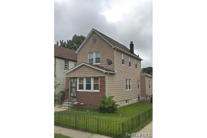 View of side of home featuring a chimney and brick siding