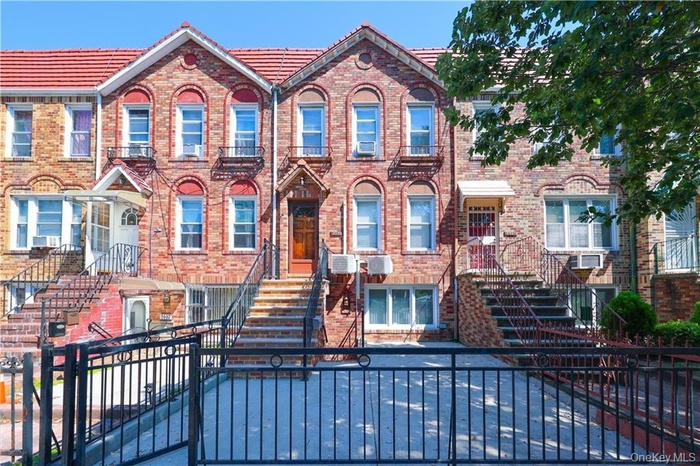 View of front of home featuring a fenced front yard, brick siding, and a gate