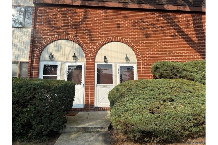 View of exterior entry with brick siding