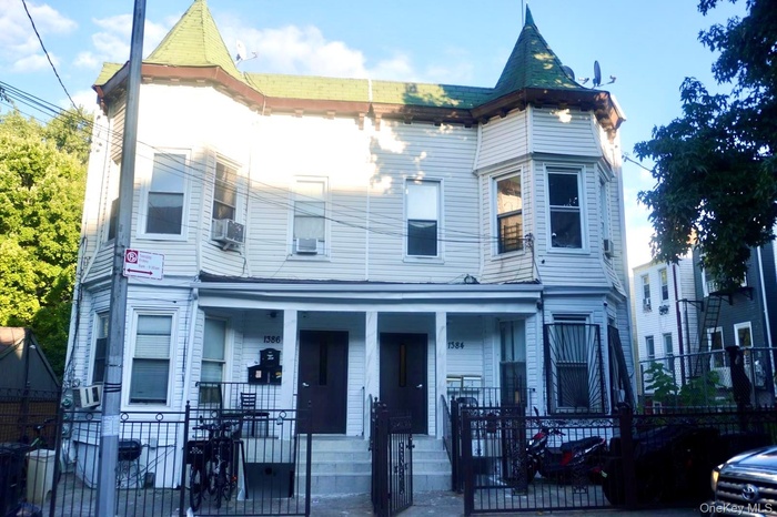 Victorian house with a gate, covered porch, and a fenced front yard