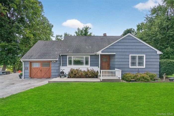 Single story home featuring a front yard, driveway, a shingled roof, a garage, and a chimney