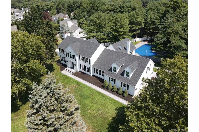 View from above of property with a pool area and a heavily wooded area
