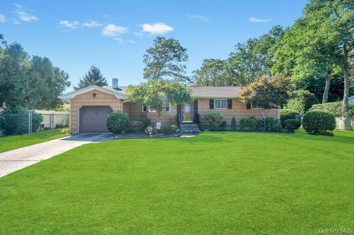 Single story home with driveway and an attached garage