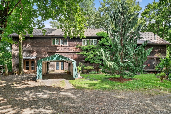 View of front of home featuring a standing seam roof, a metal roof, and a front yard