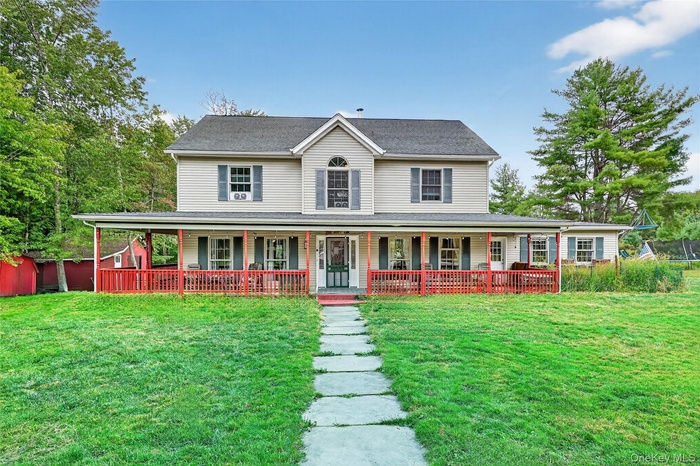 Farmhouse with a front lawn and covered porch