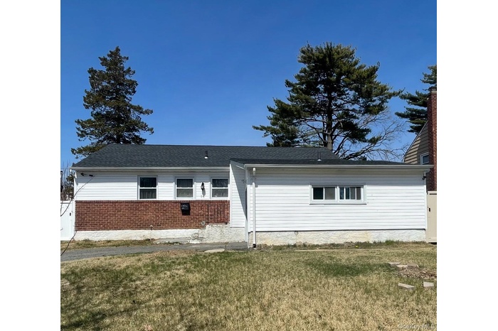 Single story home featuring a front lawn, brick siding, and a shingled roof