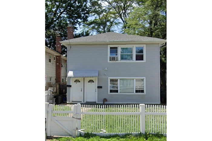 View of front of home with a fenced front yard and a gate