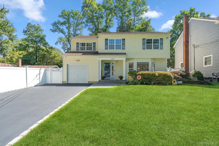 View of front of house featuring asphalt driveway and a gate