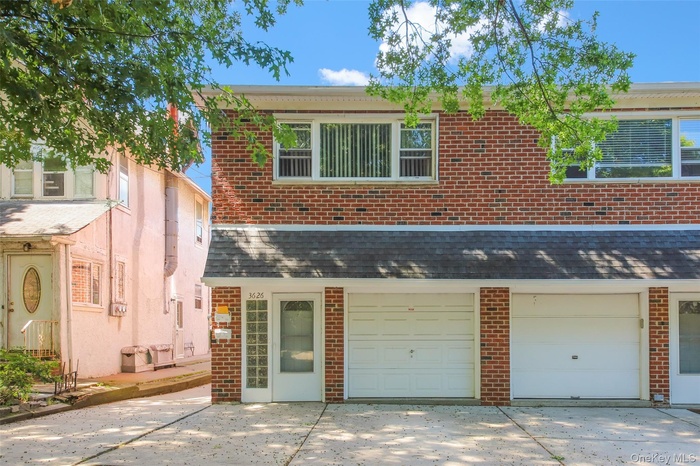 Traditional-style home featuring brick siding, driveway, and an attached garage