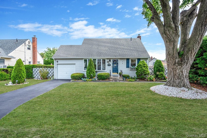 Cape cod house with driveway, a shingled roof, and a garage
