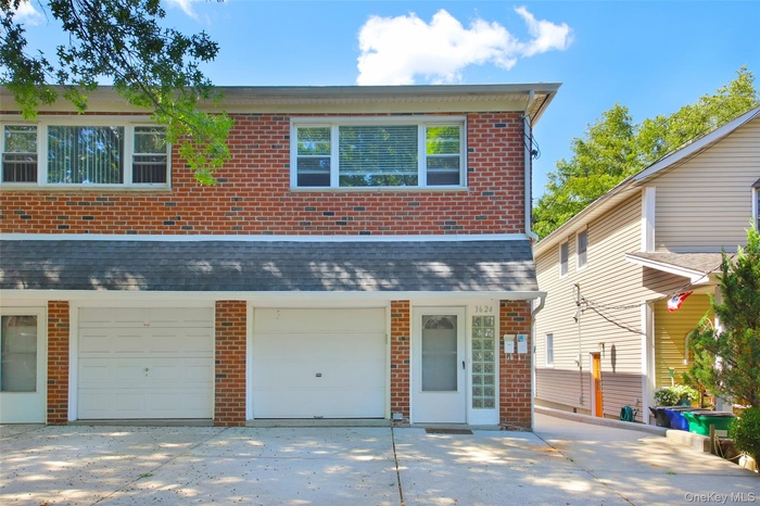 View of front of property featuring brick siding, driveway, and an attached garage