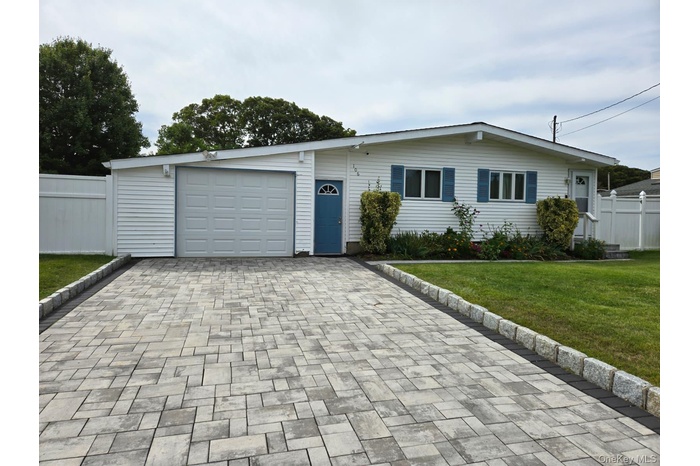 View of front facade with decorative driveway and a garage