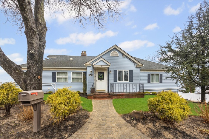 Bungalow-style home with fence, roof with shingles, a chimney, and a front lawn