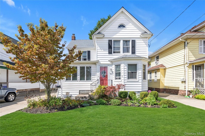 View of front facade with a front yard and a chimney