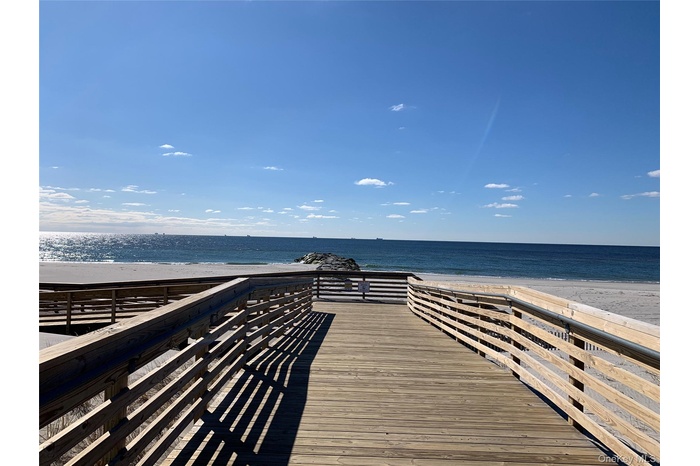 Dock with view of water and beach