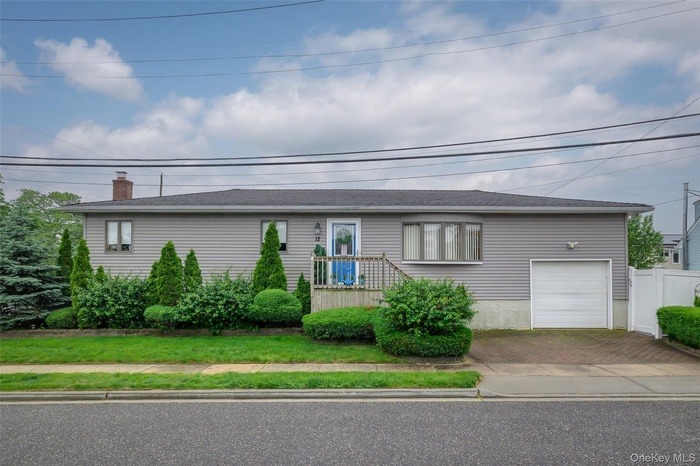 Single story home with decorative driveway, a garage, and a chimney