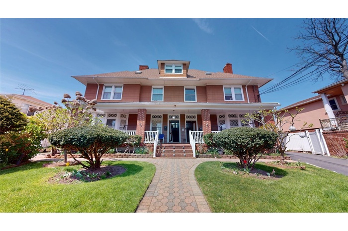 Traditional style home with a chimney, a porch, and a front lawn