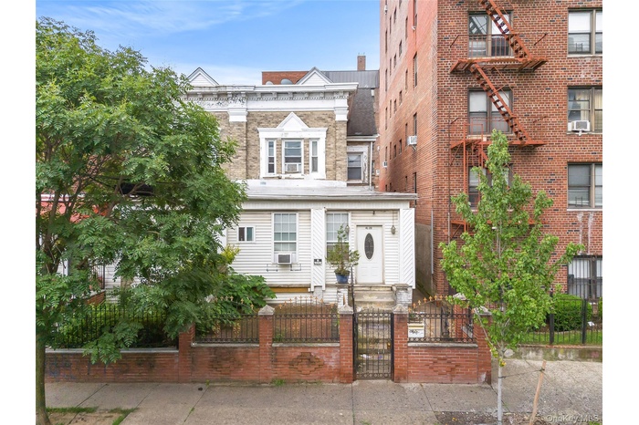 View of front facade with a fenced front yard and a gate