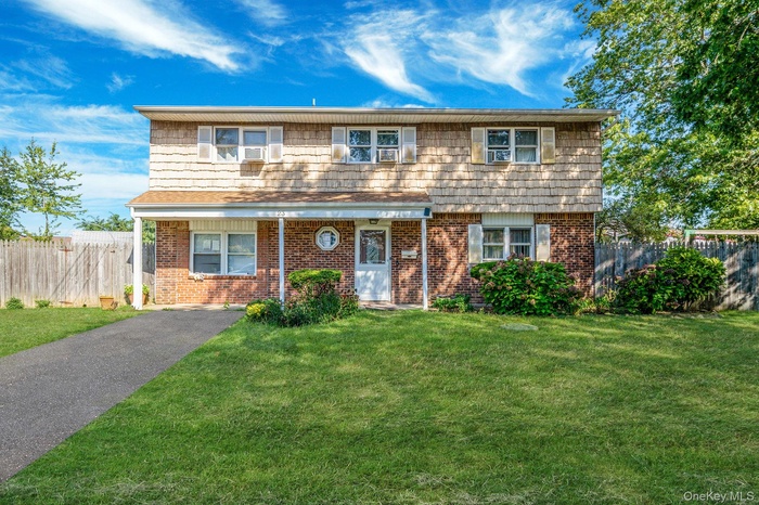 Colonial home with brick siding and driveway