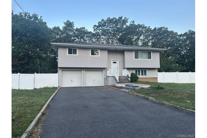 Split foyer home featuring driveway and an attached garage