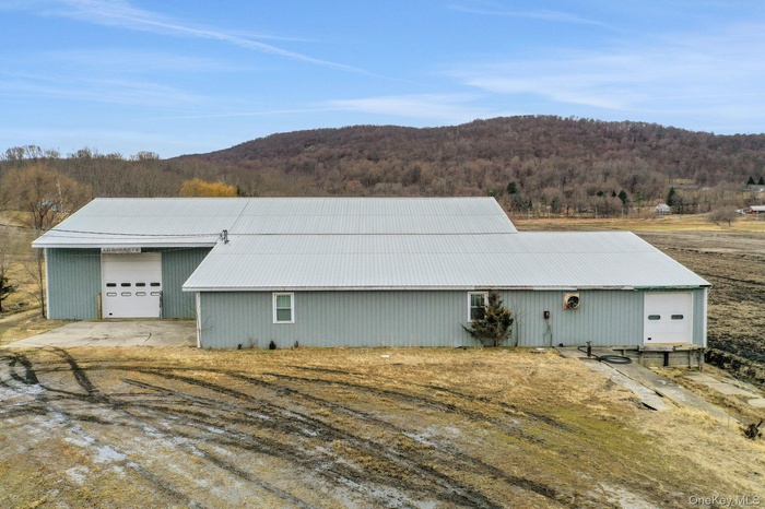 View of outdoor structure featuring a forest view and driveway