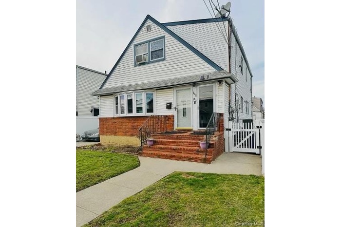 Bungalow with a gate and brick siding