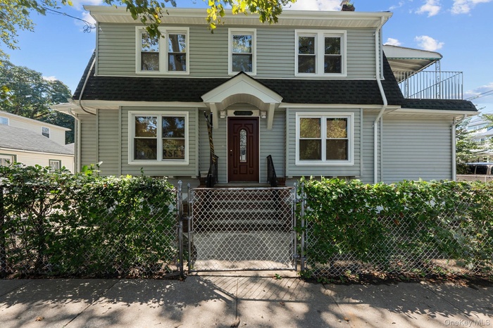 View of front of property featuring a gate, a fenced front yard, and roof with shingles