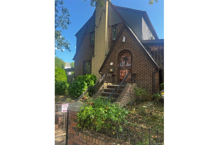 Tudor-style house with brick siding and a chimney