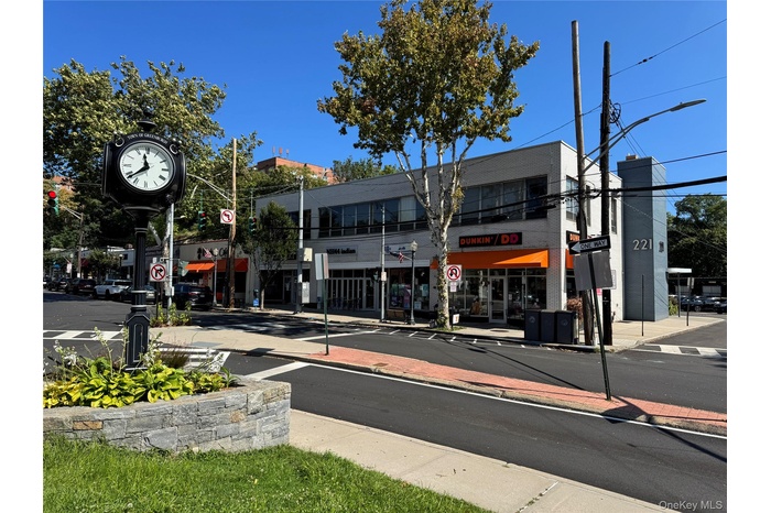 View of asphalt road with street lights, traffic signs, curbs, and sidewalks