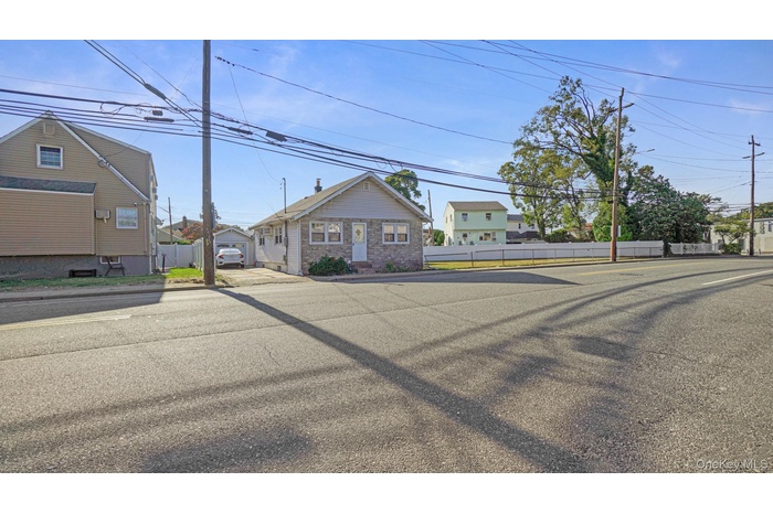 View of asphalt road with curbs, street lights, and sidewalks