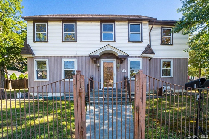 View of front of house with a fenced front yard and a gate