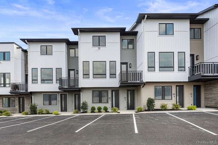 View of property featuring uncovered parking