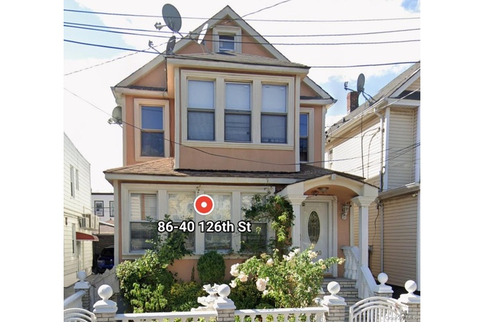 Victorian home featuring a fenced front yard and stucco siding