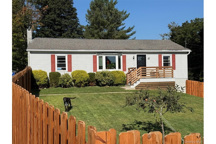 View of front of house featuring a shingled roof and a chimney