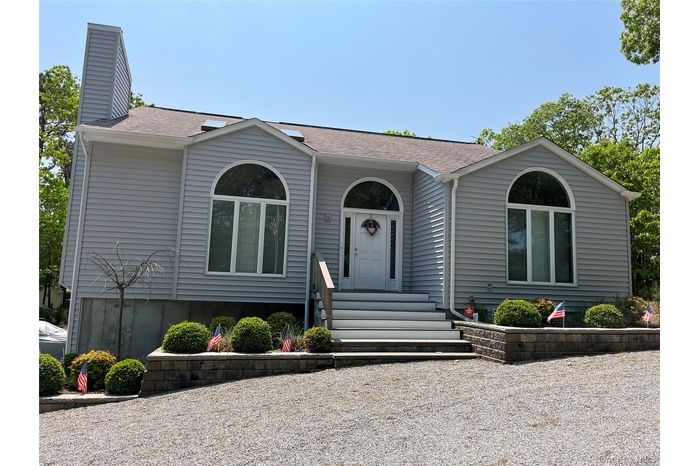 View of front of house with roof with shingles and a chimney
