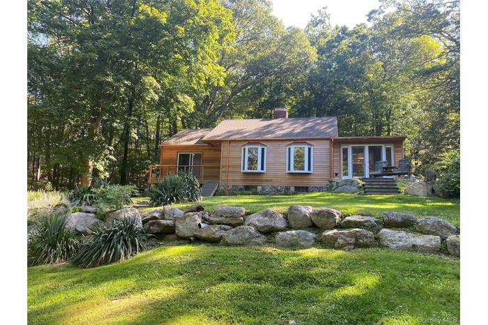 Chalet / cabin featuring a front yard and a chimney