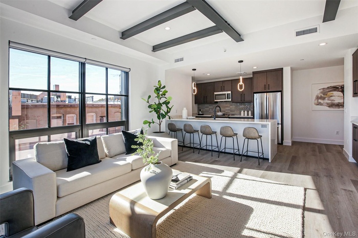 Living room with beamed ceiling, dark hardwood / wood-style floors, and sink