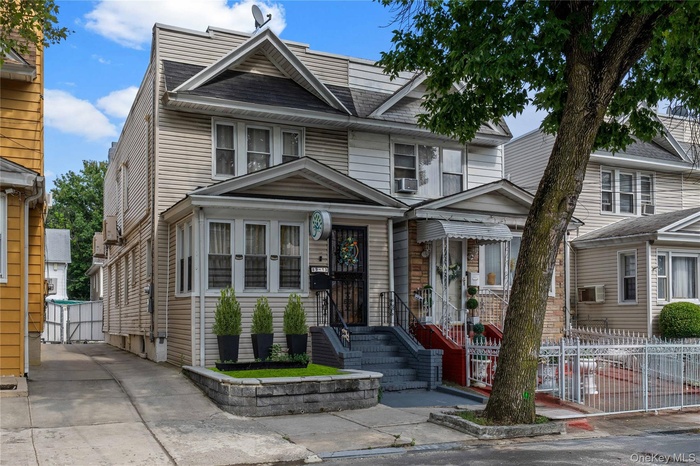 American foursquare style home featuring a gate and roof with shingles