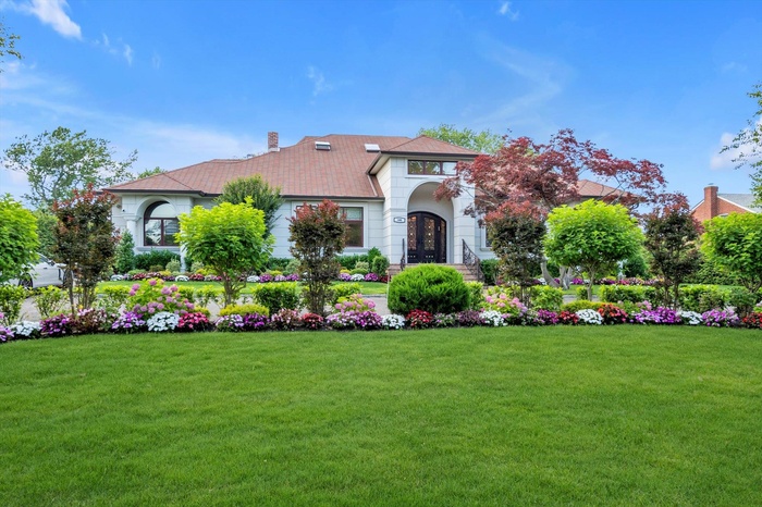 View of front of property with french doors, a chimney, and a front lawn