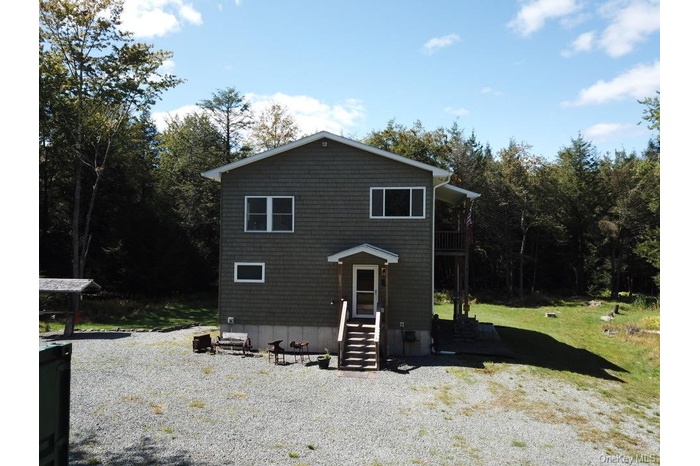 View of front of house with a wooded view