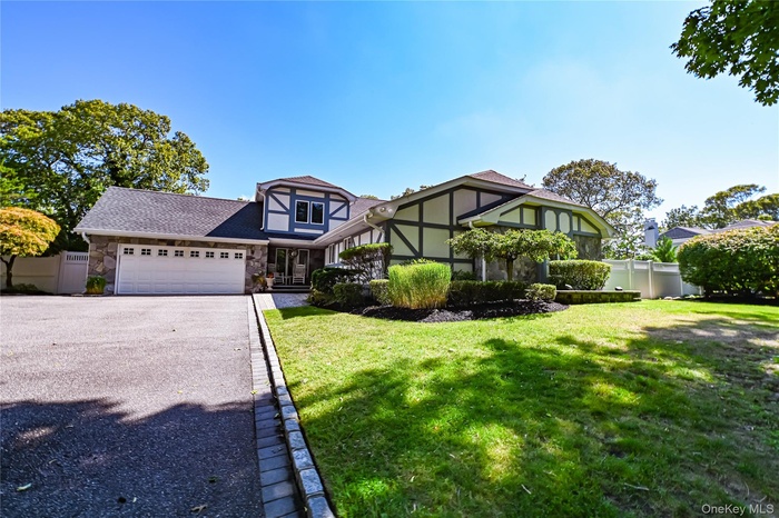 English style home featuring stone siding, asphalt driveway, a shingled roof, a garage, and stucco siding